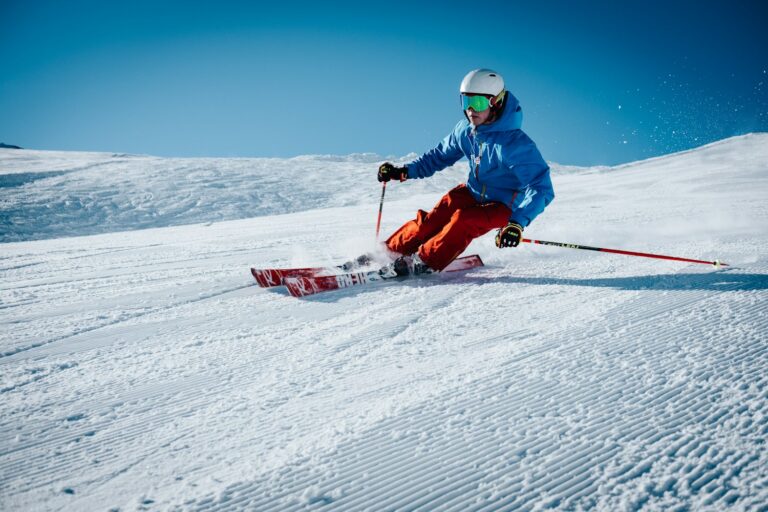 Skiër daalt een zonnige piste af