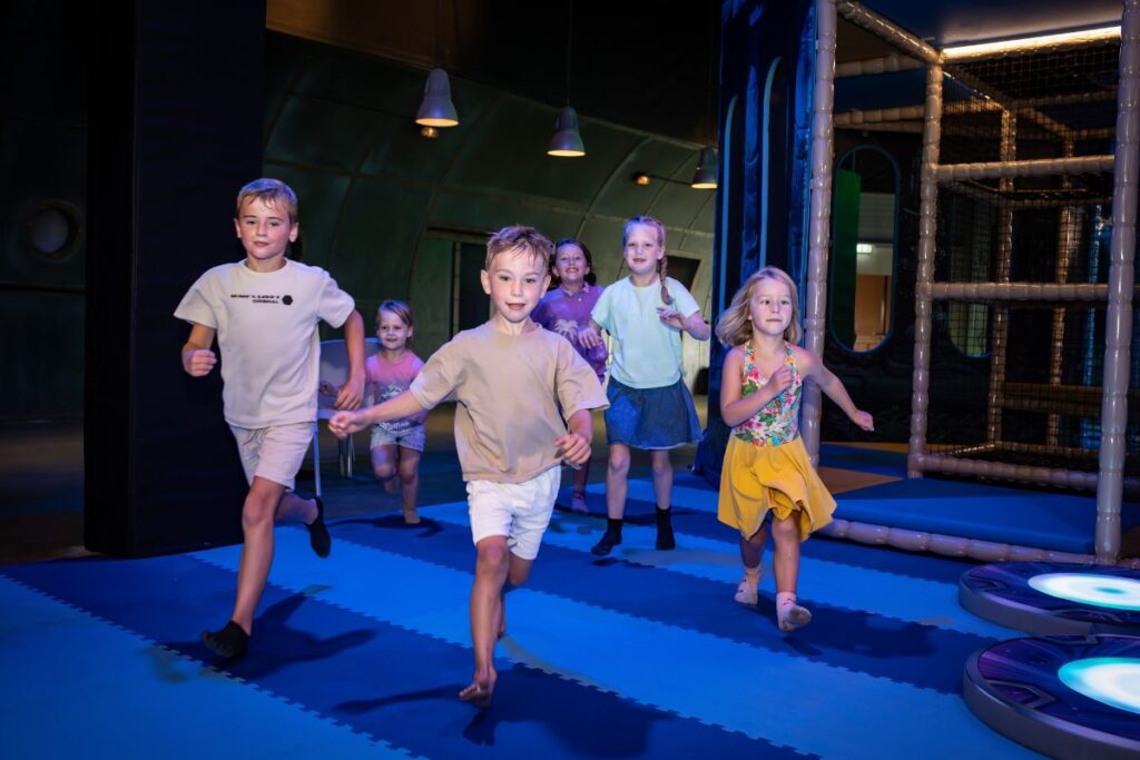 Kinderen rennen door de speelhal van Atlantis