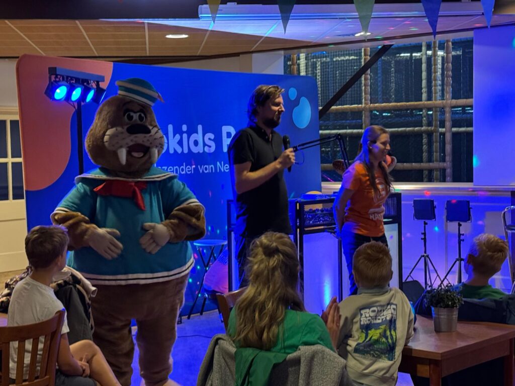 Mascotte geeft een high five tijdens de opening van Atlantis