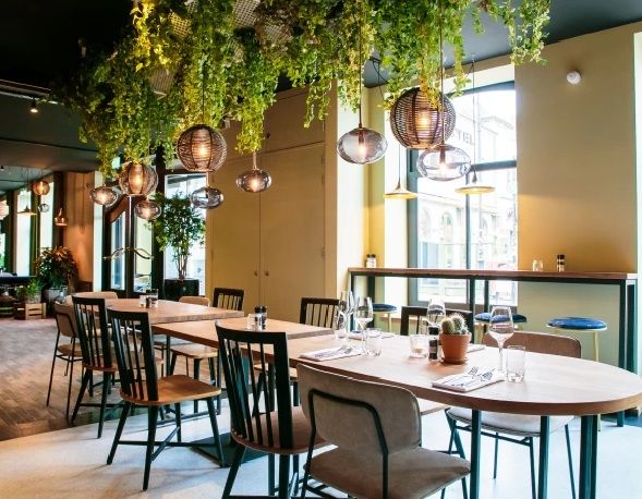 Restaurantzaal met tafels en hanglampen