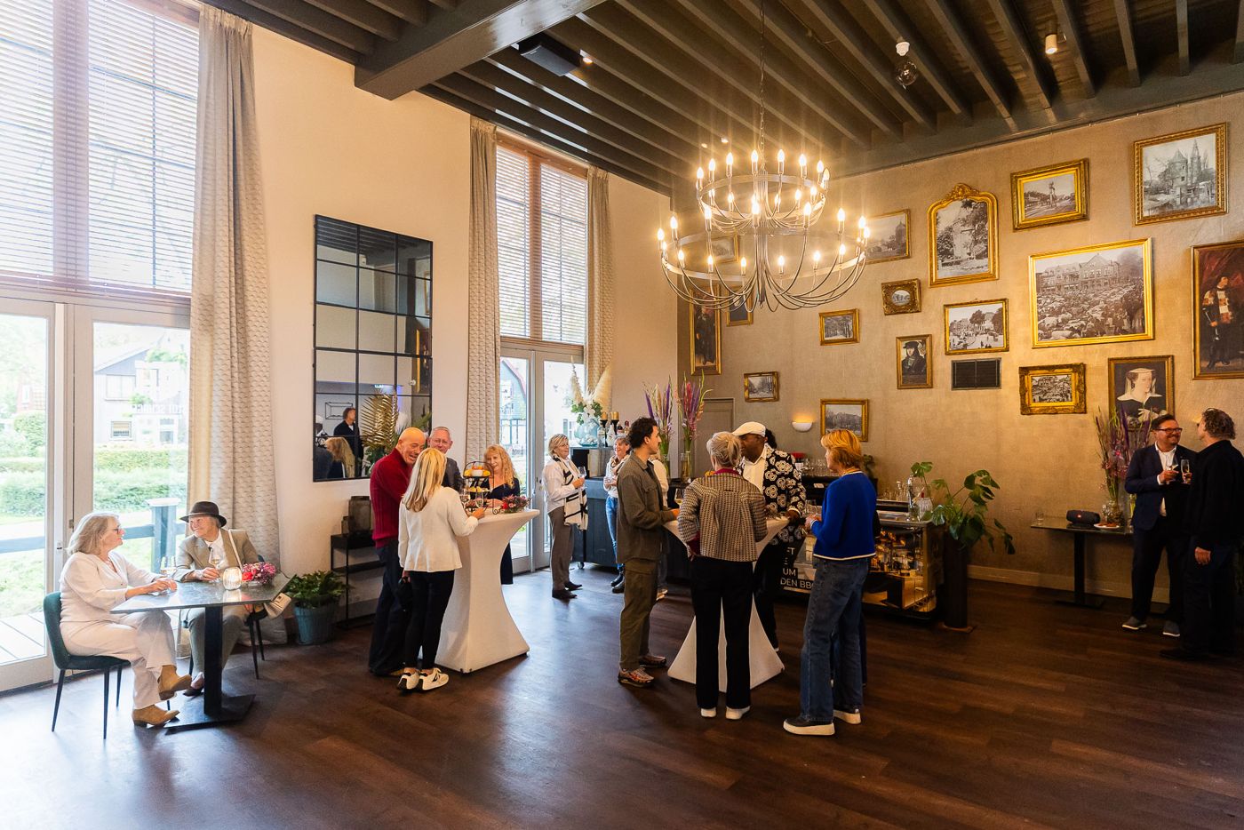 Gasten tijdens een bijeenkomst in een zaal met historische schilderijen