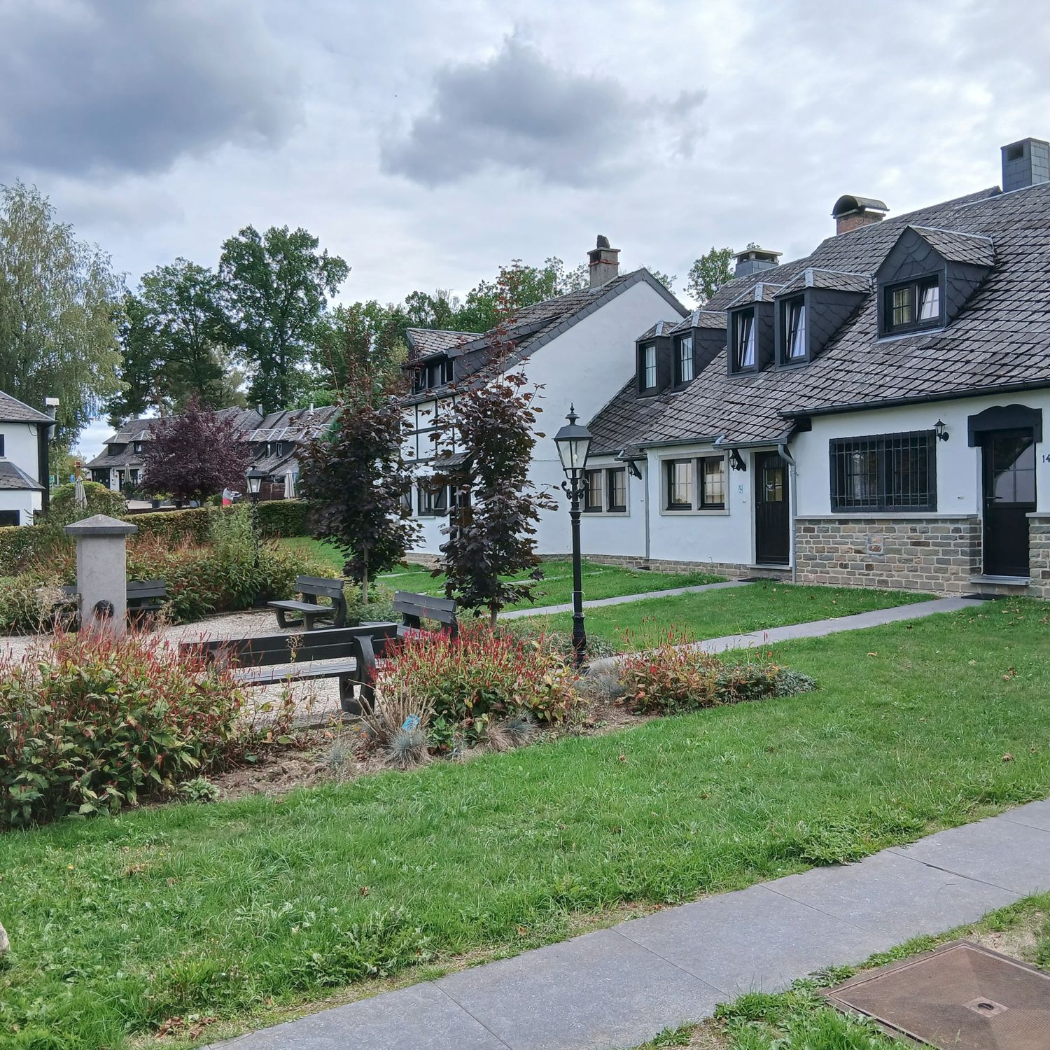 Bungalows en bankjes langs het pad op Village les Cottales