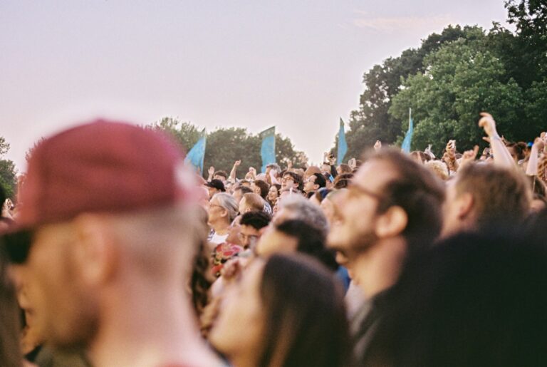Festivalpubliek in de buitenlucht bij avondlicht