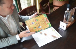 Robert Visser laat zien hoe de menukaart bij Center Parcs kindvriendelijk is opgemaakt
